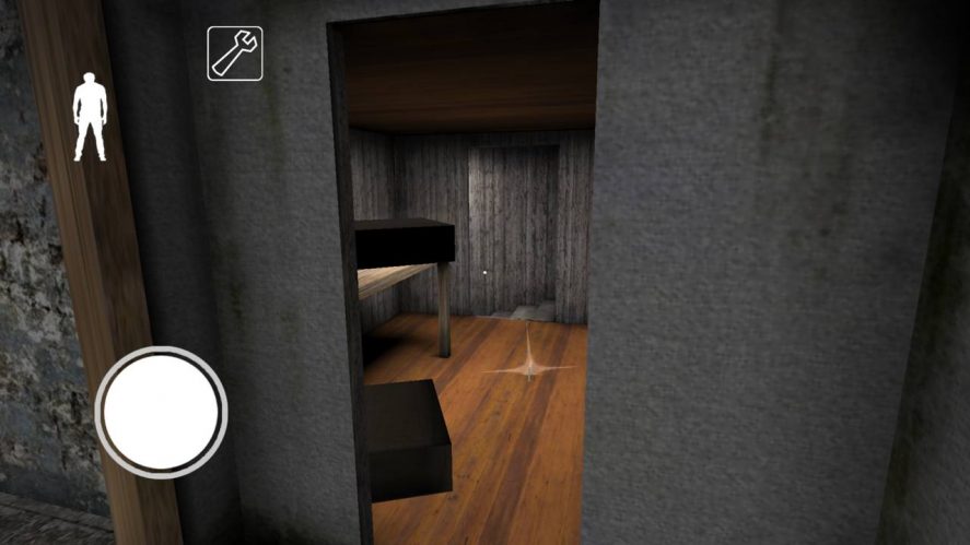 Granny's secret room with wooden floor, gray walls, a table, and two black boxes