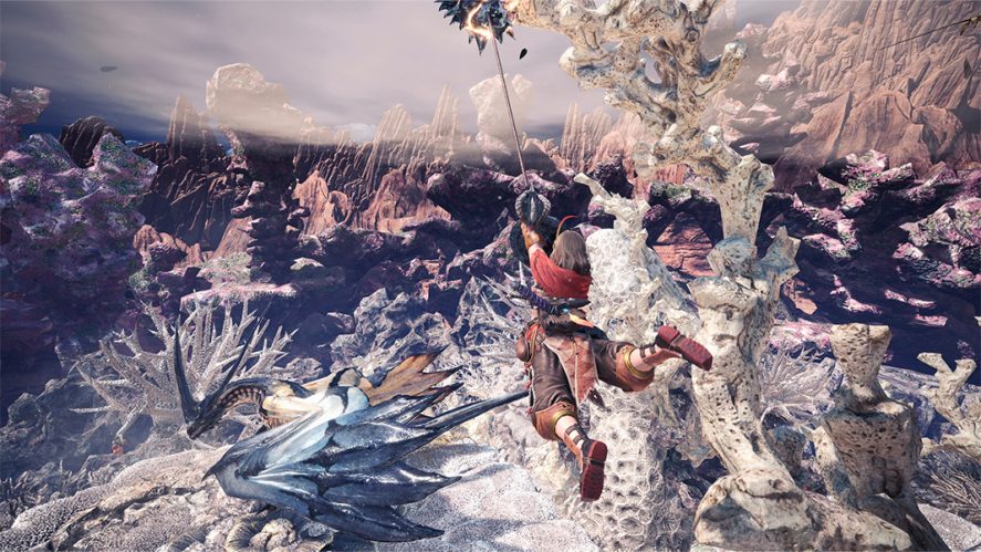 Monster Hunter World: character jumping with the help of a vine in a rocky landscape.