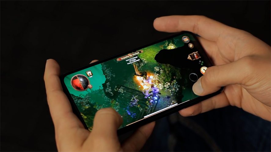 Hands of a person playing Path of Exile Mobile on a mobile device